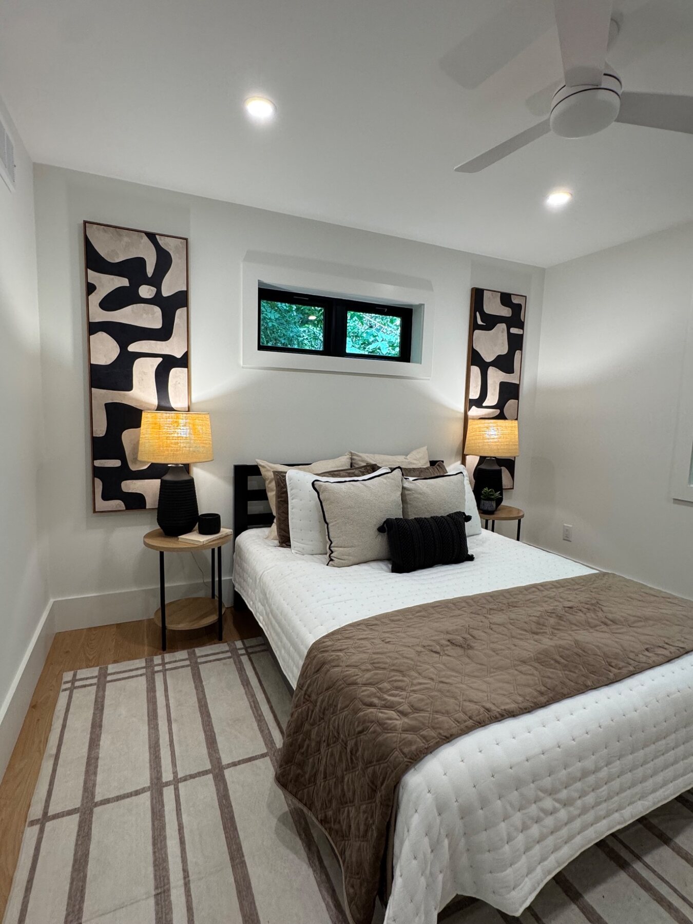 Modern bedroom staged with graphic black and cream artwork